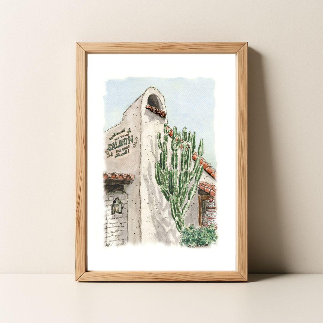 Framed watercolor painting of a building with a cactus and the word "Saloon".