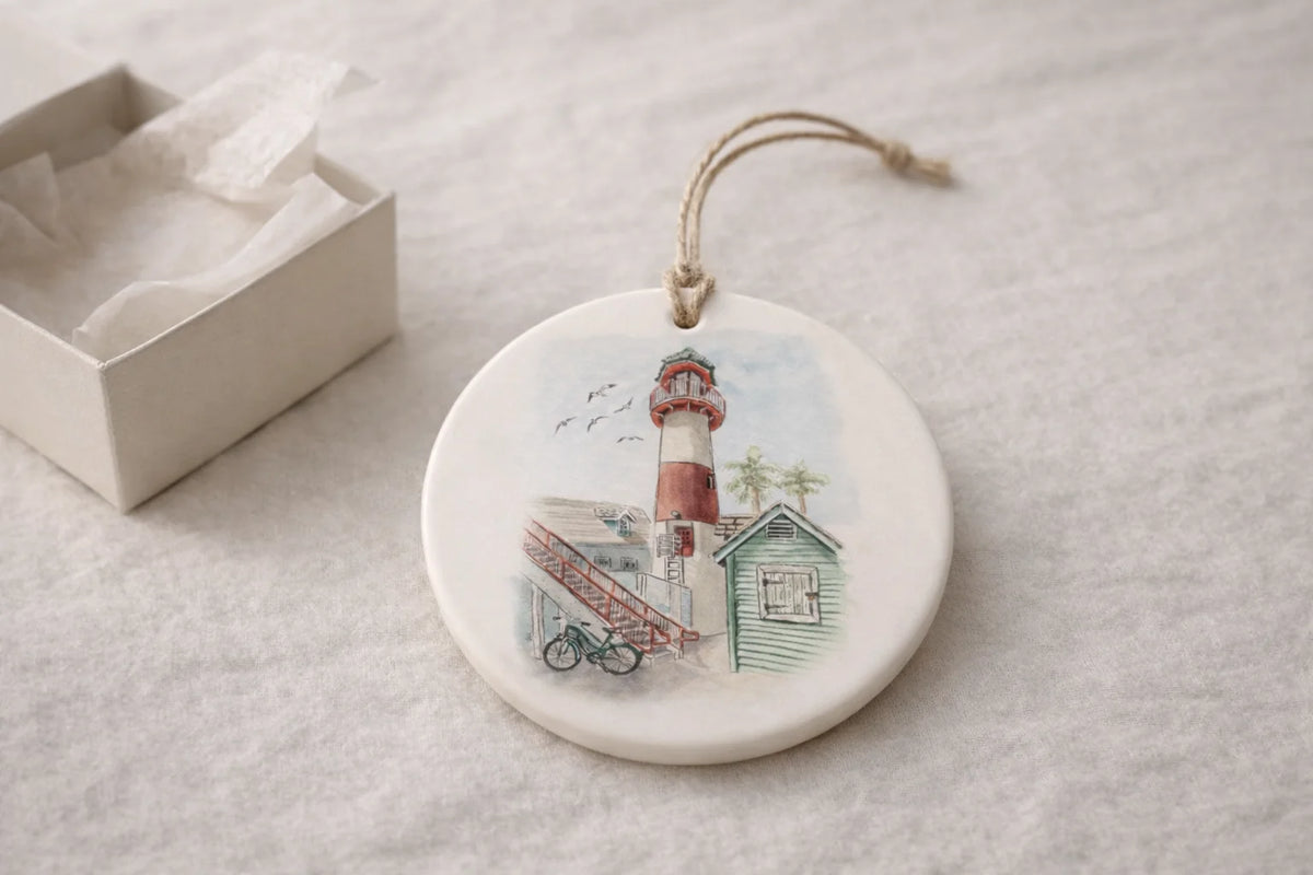 Round ceramic ornament with lighthouse design on a light gray surface. Illustration by Swil Arts