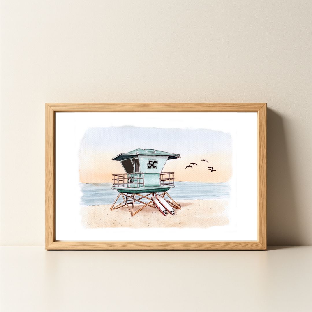 Watercolor painting of a lifeguard tower on the beach in a wood frame.