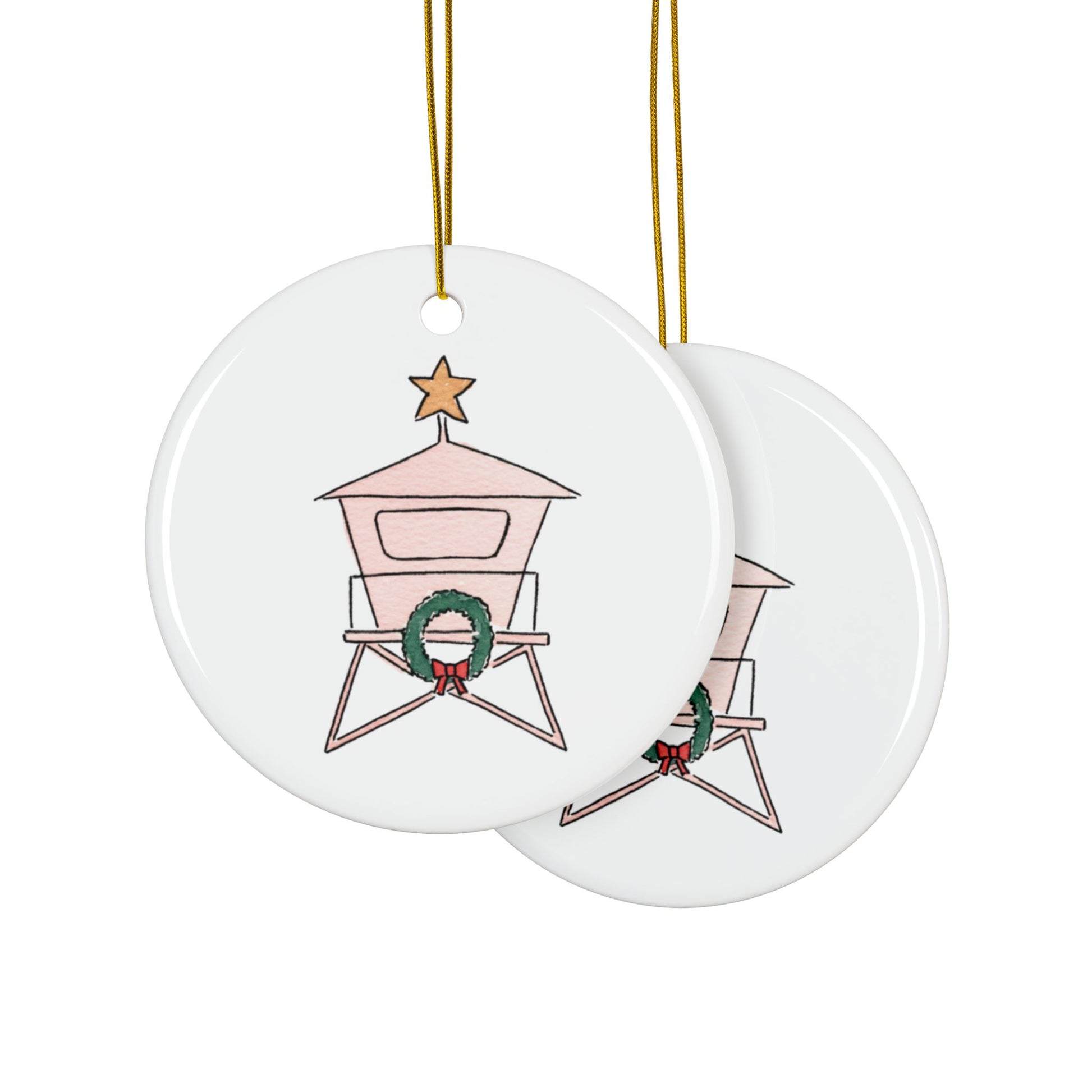Two round ceramic ornaments with a lifeguard tower design featuring a wreath, on a white background.