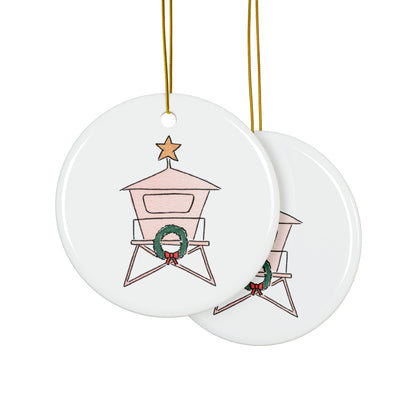 Two round ceramic ornaments with a lifeguard tower design featuring a wreath, on a white background.