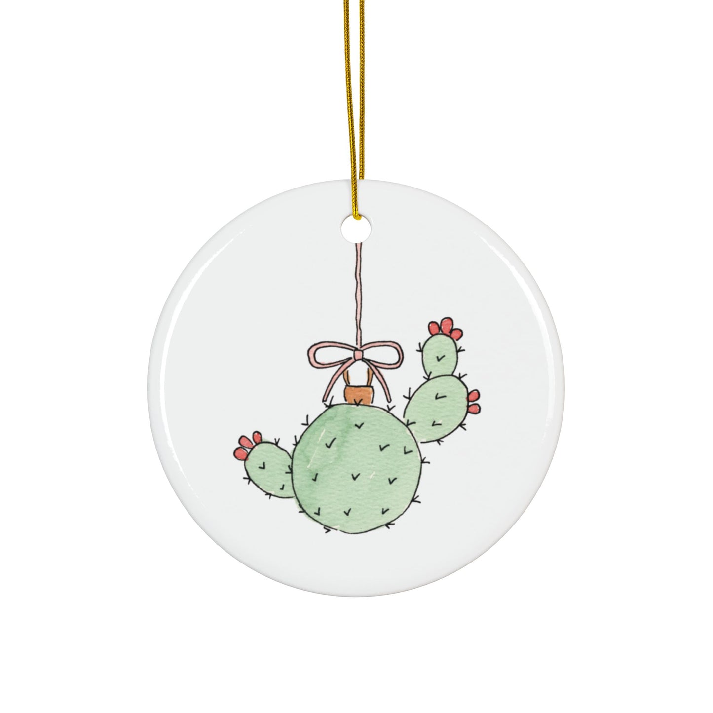 Round ceramic ornament with a cactus design and a bow, hanging on a white background.