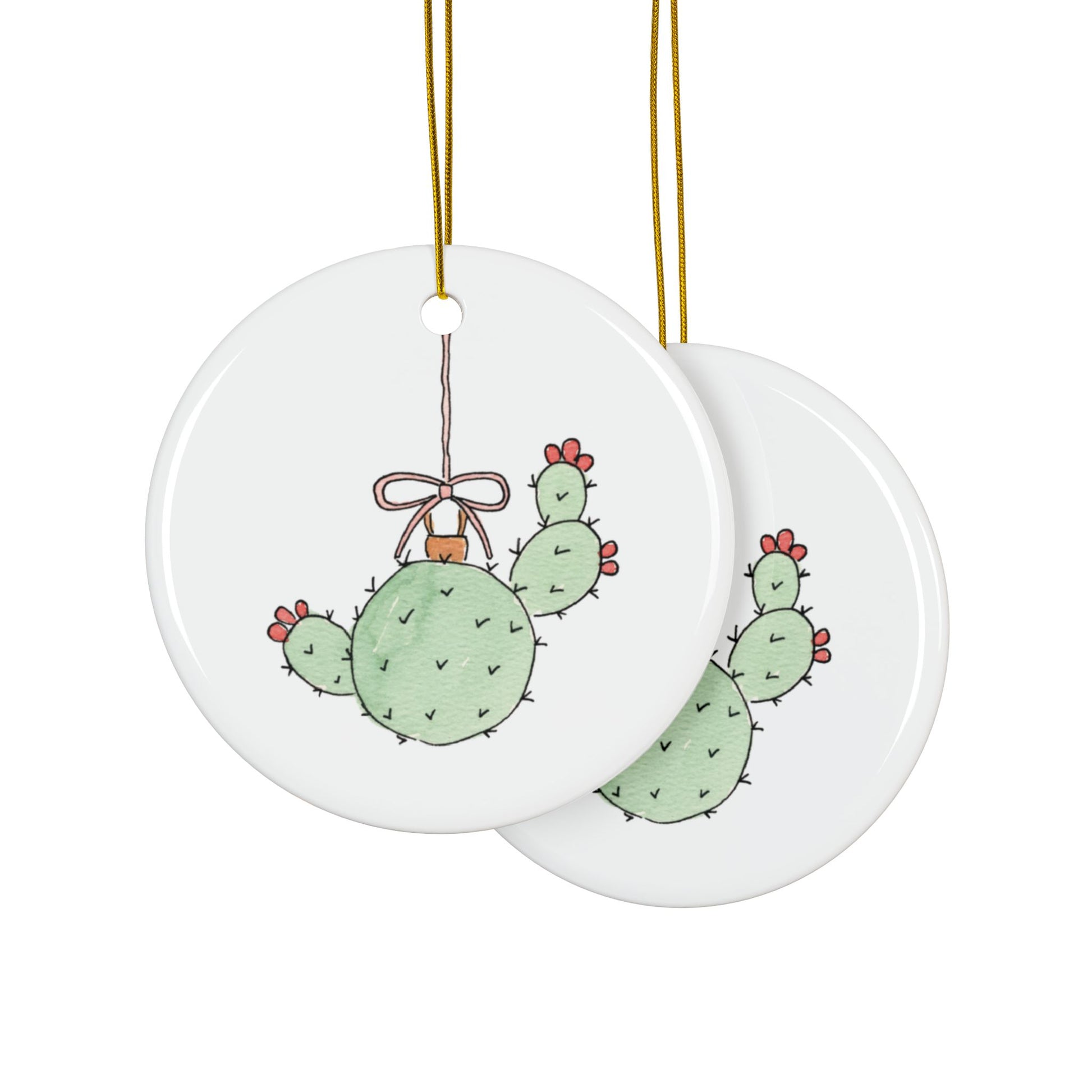 Two round ceramic ornaments with cactus designs on a white background