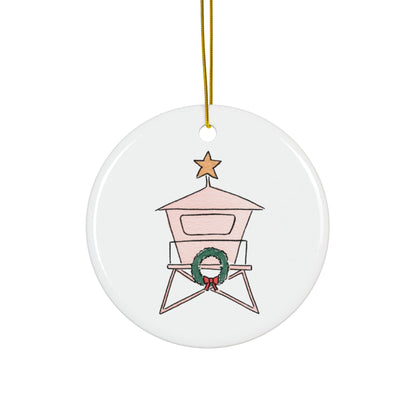 Round ceramic ornament with a lifeguard tower design, featuring a wreath and star on a white background.