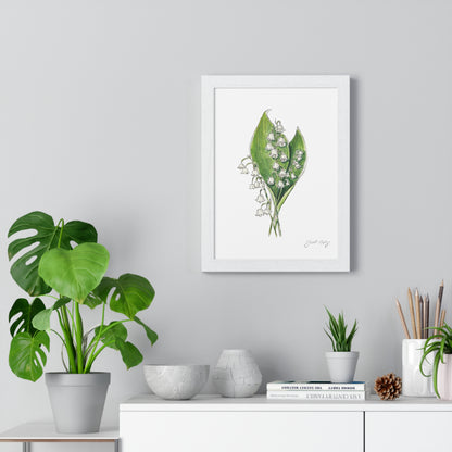 Minimalist interior showcasing a framed botanical watercolor of white lily of the valley flowers with green leaves, signed by 'Swil Arts.' The artwork is hung on a light gray wall above a white cabinet, styled with modern decor: a monstera plant in a gray pot, textured vases, books, and a small collection of pencils in a ceramic holder. Natural elements like pinecones and greenery add a cozy touch.