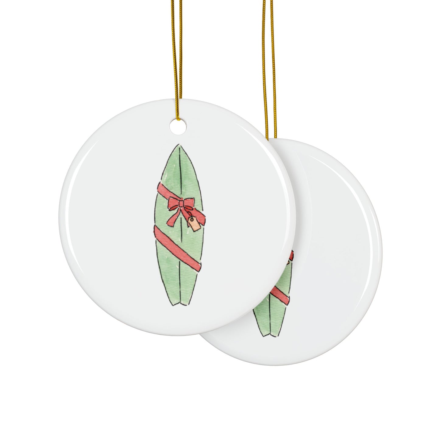 Two round ceramic ornaments with green surfboards and red bows on a white background