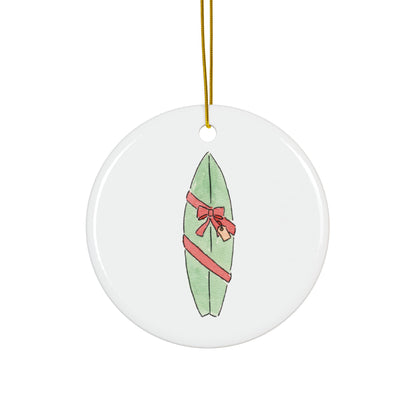 Round ceramic ornament with a green surfboard wrapped as a gift design on a white background