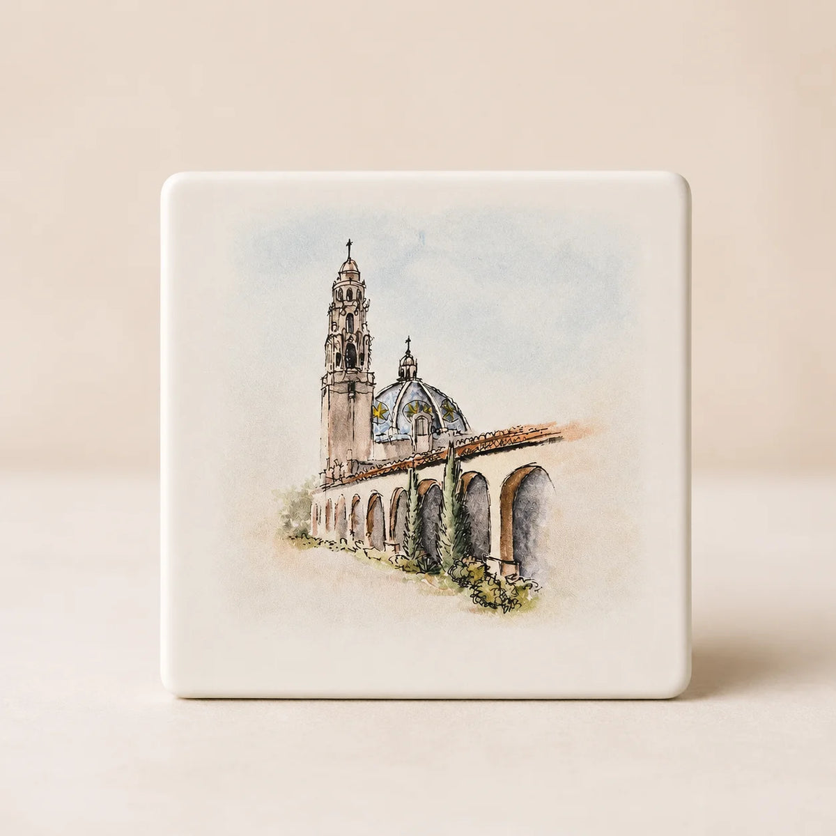Square ceramic tile with a watercolor painting of an architectural landmark by Sara of Swil Arts, set on a beige background.