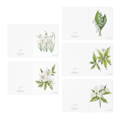 Set of botanical watercolor folded note cards by Swil Arts, featuring hand-painted floral illustrations. Each blank greeting card displays a delicate ink and watercolor rendering of flowers, including snowdrops, anemones, lily of the valley, and trillium. The back of each card includes the Swil Arts logo and website, swilarts.com. Perfect for nature lovers, botanical art enthusiasts, and handwritten messages, these eco-friendly cards combine artistic elegance with sustainability.