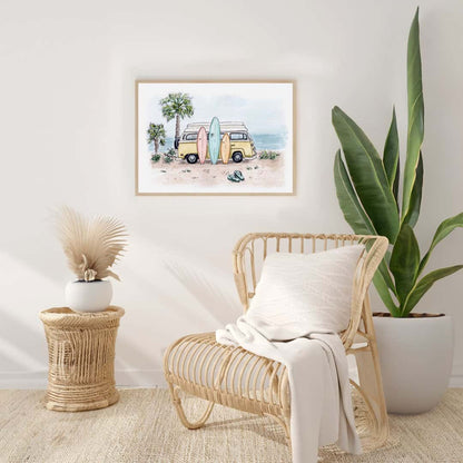 Framed watercolor print of a beach scene with a yellow camper van and surfboards, displayed in a modern, coastal-style living room with rattan furniture and neutral tones. The artwork adds a laid-back, beachy vibe to the minimalist, nature-inspired decor.