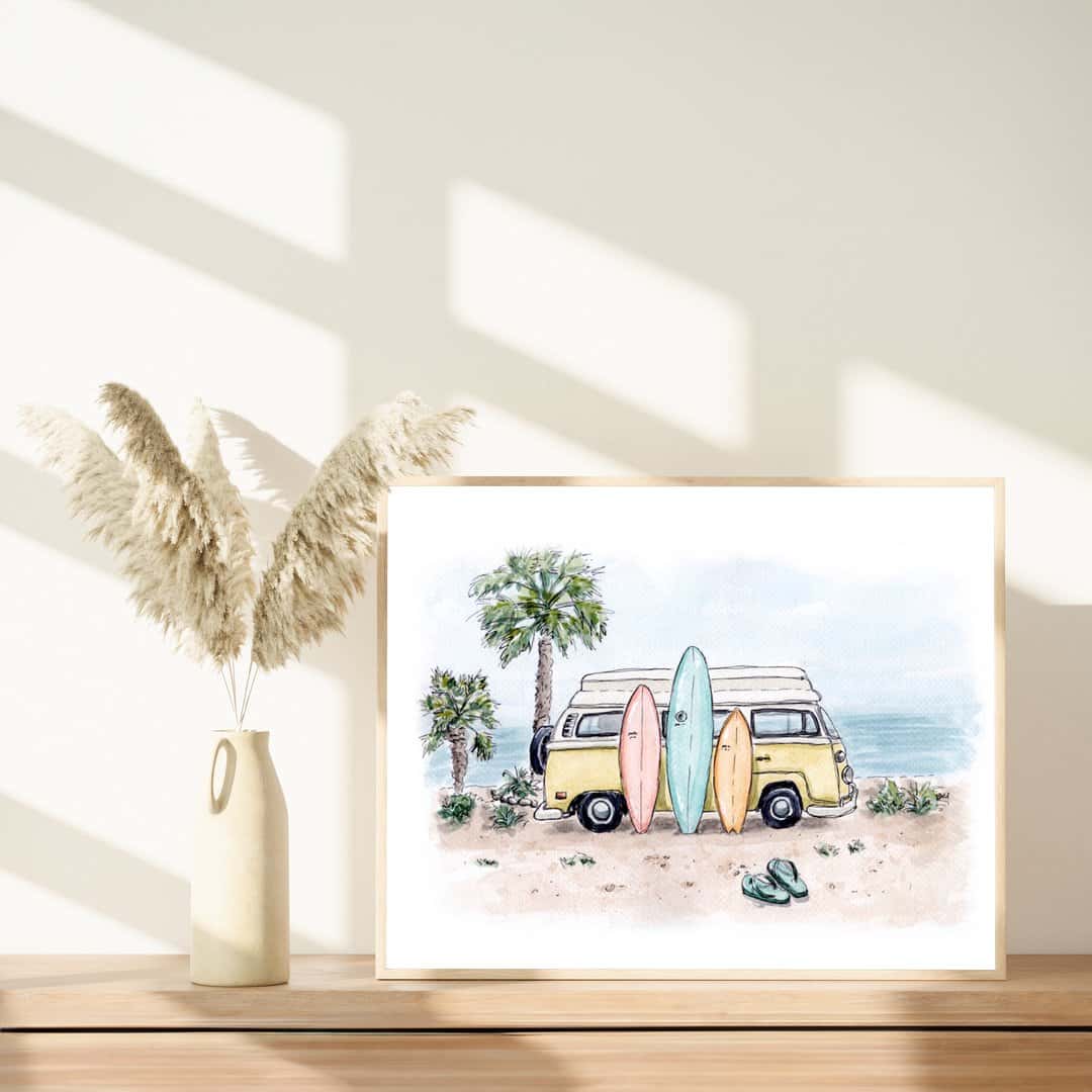 Framed watercolor print of a yellow vintage van with surfboards on a beach, styled with pampas grass in a minimalist decor setup. Palm trees and ocean view in the background. Ideal surf and beach-themed wall art for coastal home decor
