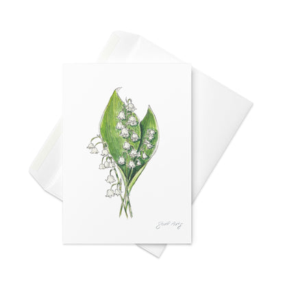Lily of the Valley flower greeting card with watercolor and ink botanical illustration. Elegant woodland-inspired note card with blank interior, perfect for nature lovers and special occasions. Sophisticated with white envelope below it.
