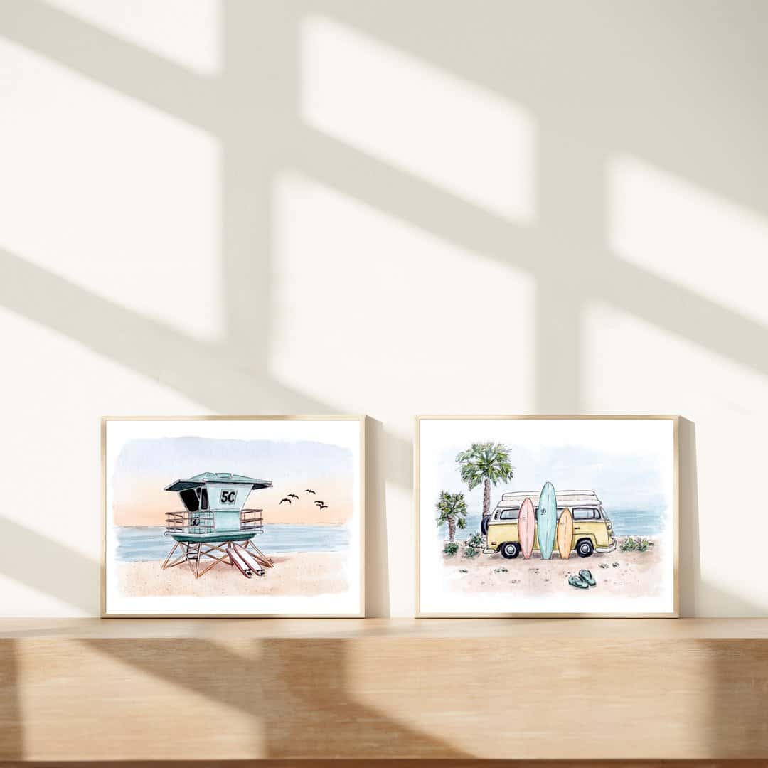 Set of two coastal watercolor prints featuring beach scenes: a lifeguard tower at sunset with birds flying, and a vintage yellow surf van with surfboards against a beach backdrop and palm trees. Framed beach wall art perfect for surf enthusiasts and ocean-inspired home decor.