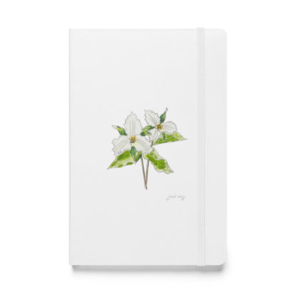 White hardcover notebook featuring a delicate trillium flower illustration by Swil Arts. This botanical watercolor and ink design showcases the beauty of nature, making it perfect for journaling, sketching, or note-taking. The notebook includes an elastic closure for convenience, ideal for artists, writers, and nature lovers seeking elegant stationery with a floral touch