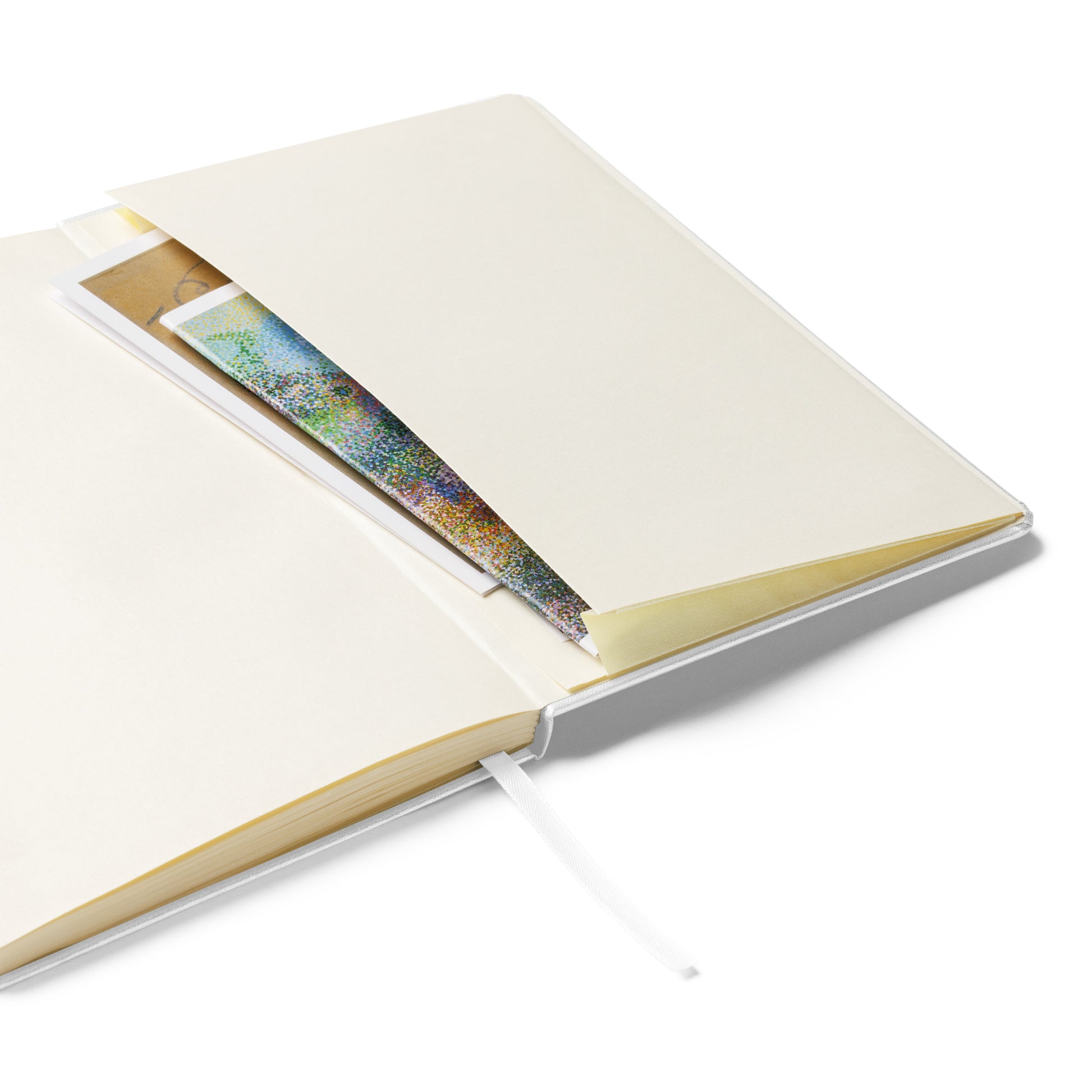 Open hardcover notebook with an inner storage pocket holding colorful paper and notes. Cream-colored pages, built-in ribbon bookmark, and sturdy binding make it ideal for journaling, sketching, or note-taking.