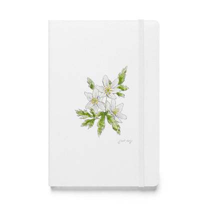 White hardcover notebook featuring a delicate wood anemone flower illustration by Swil Arts. This botanical watercolor and ink design showcases the beauty of nature, making it perfect for journaling, sketching, or note-taking. The notebook includes an elastic closure for convenience, ideal for artists, writers, and nature lovers seeking elegant stationery with a floral touch