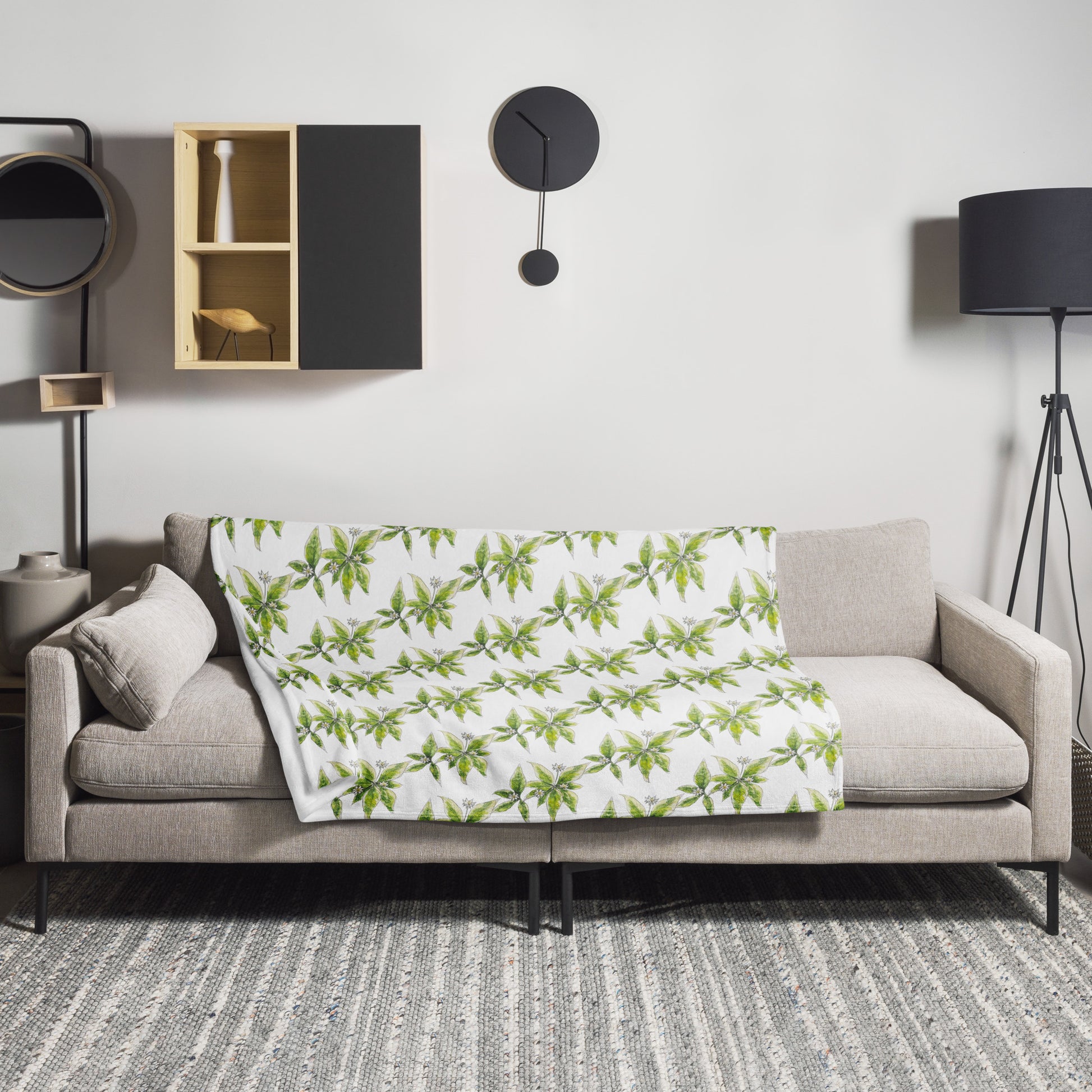 Cozy throw blanket with a starflower pattern draped over a modern beige sofa in a stylish living room. Nature-inspired home décor, perfect for adding botanical charm to any space.