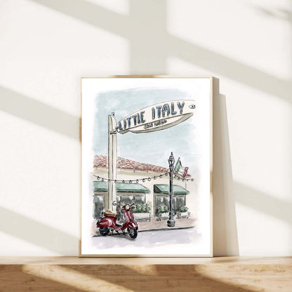 Framed watercolor print of Little Italy San Diego sign with a red Vespa scooter. Hand-painted Italian-inspired street scene art, perfect for stylish wall décor or travel-themed home accents