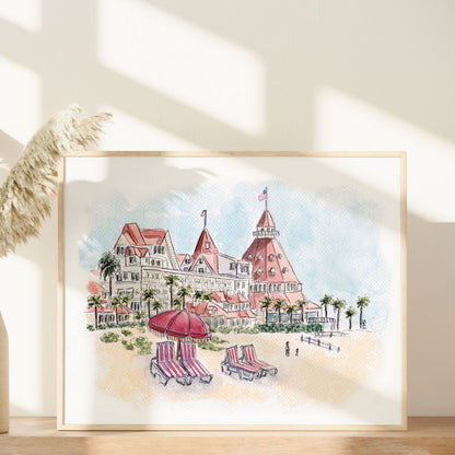 The Del’s Timeless Charm by Swil Arts is a framed watercolor of Hotel del Coronado’s red roofs, beach umbrellas, palms, and sunlit sand—an iconic California art piece displayed on wood for a vibrant seaside vibe.